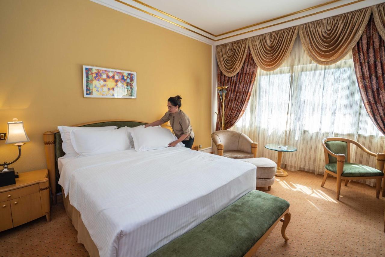 Officers Club & Hotel Abu Dhabi Exterior foto A chambermaid making a bed in a hotel room